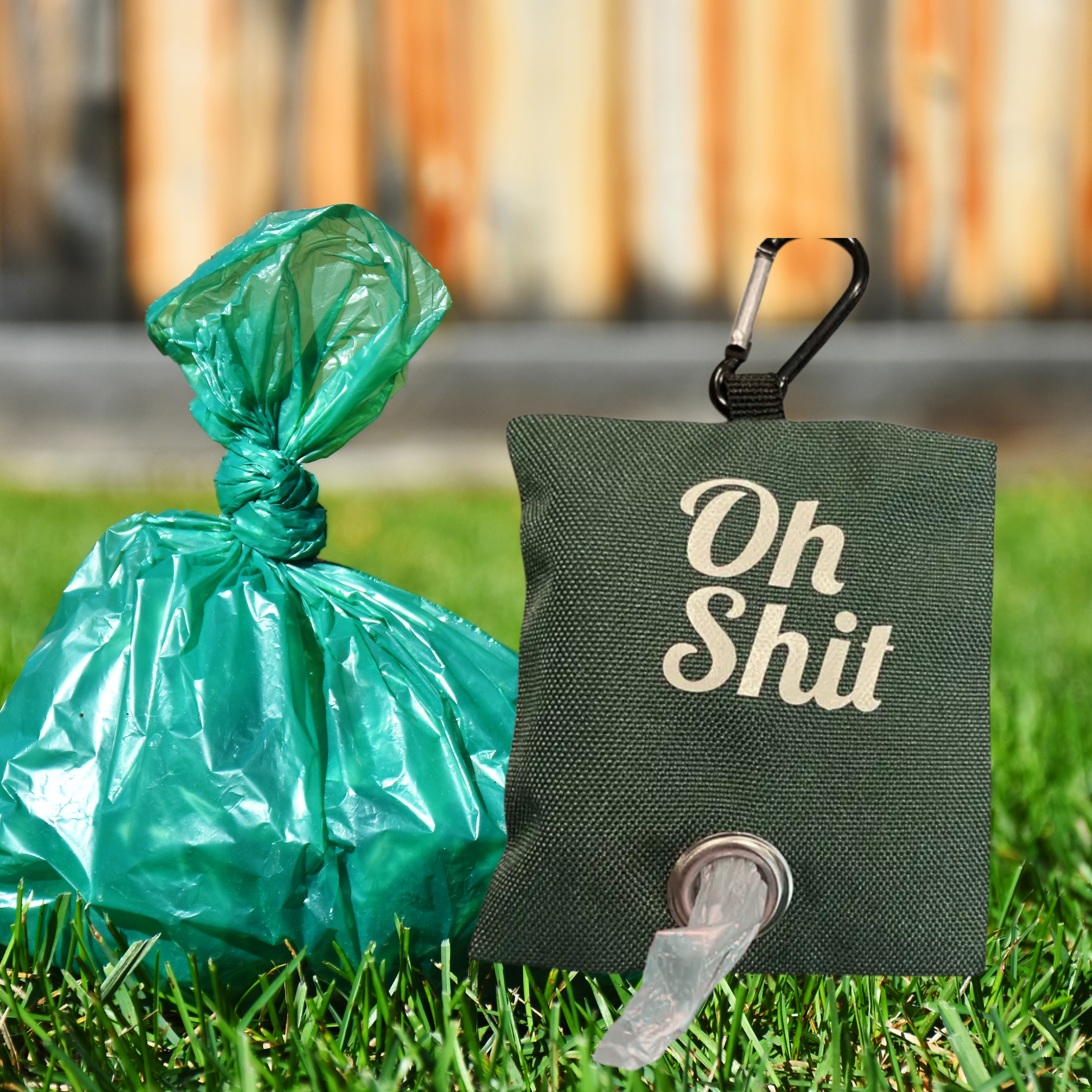 Green bag with a carabiner and 'Oh Shit' text on grass